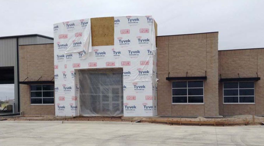 A building that is being built with a lot of plastic on it.