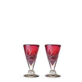 Two red wine glasses with a floral design on them on a white background.