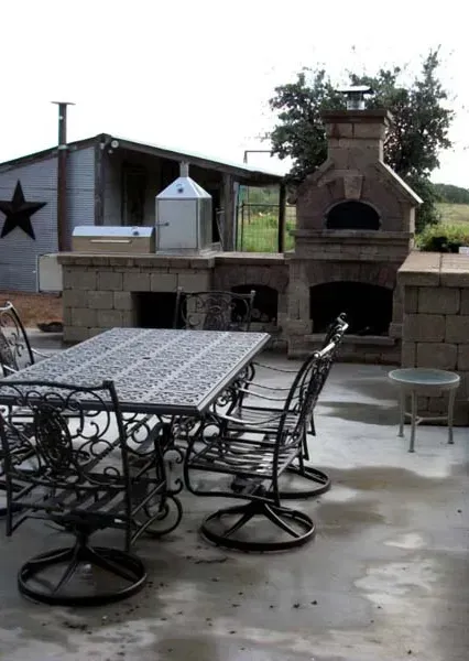 A patio with a table and chairs and a fireplace