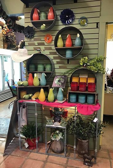 A display of candles and potted plants in a store.