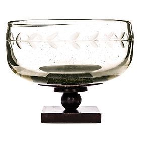 A glass bowl on a wooden base on a white background.