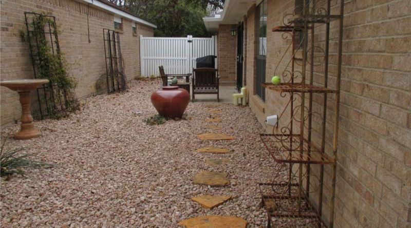 A brick house with a walkway leading to the backyard