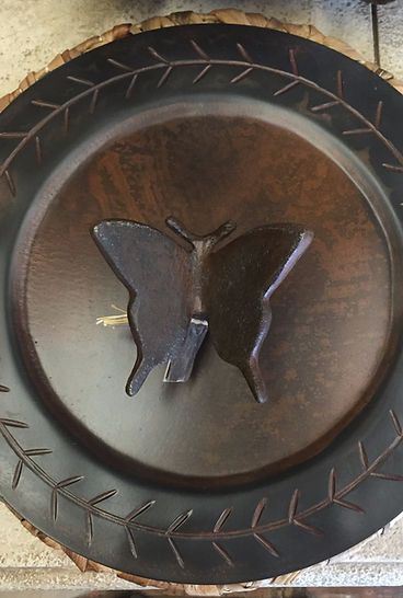 A black plate with a butterfly on it