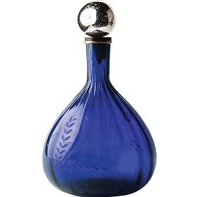 A blue glass bottle with a silver lid on a white background.