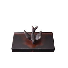 A small statue of a bird sitting on top of a wooden box.