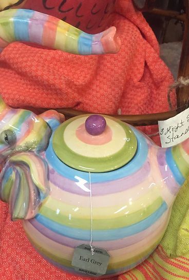 A rainbow colored teapot with a purple lid