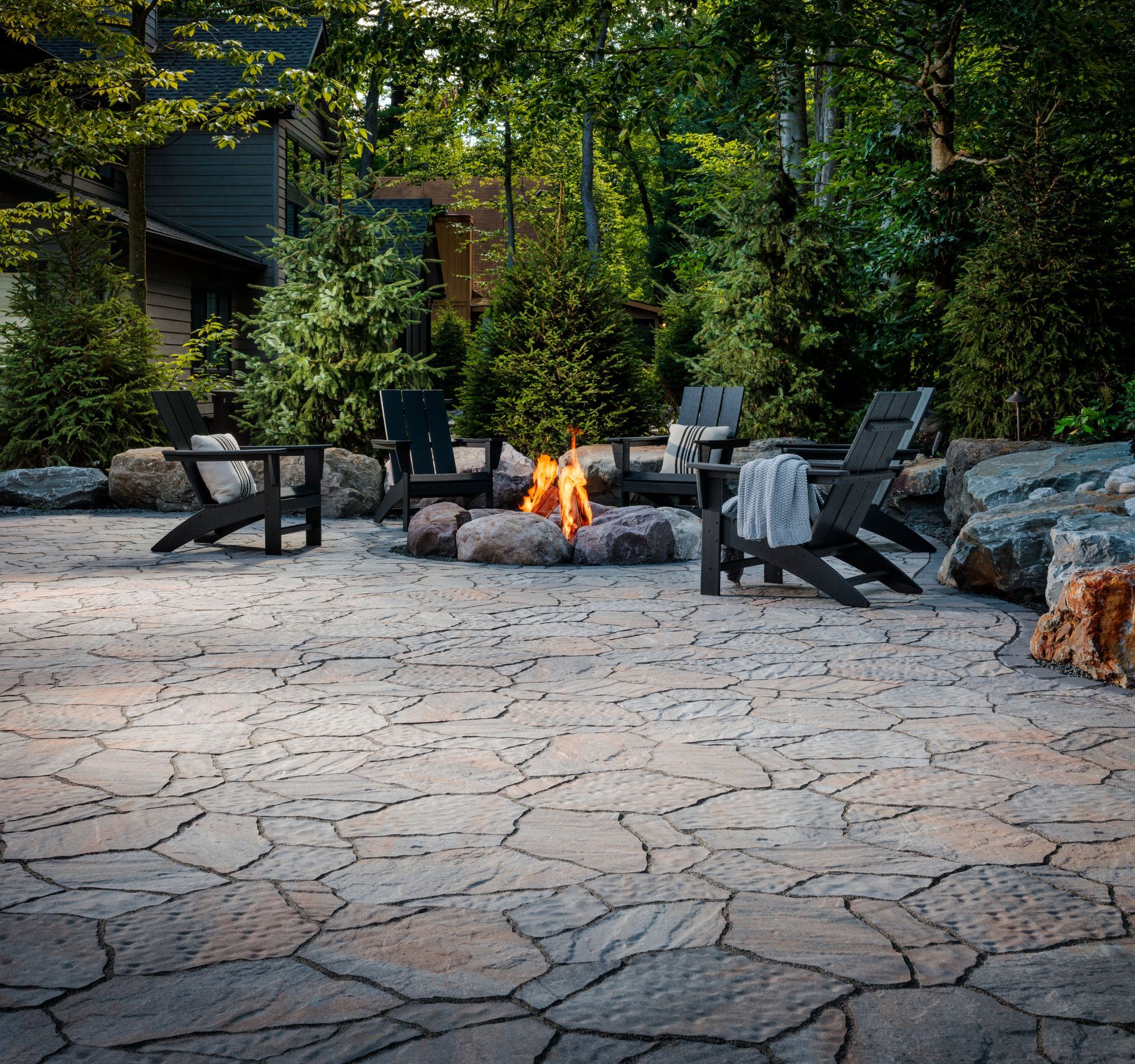 A patio with chairs and a fire pit in the middle