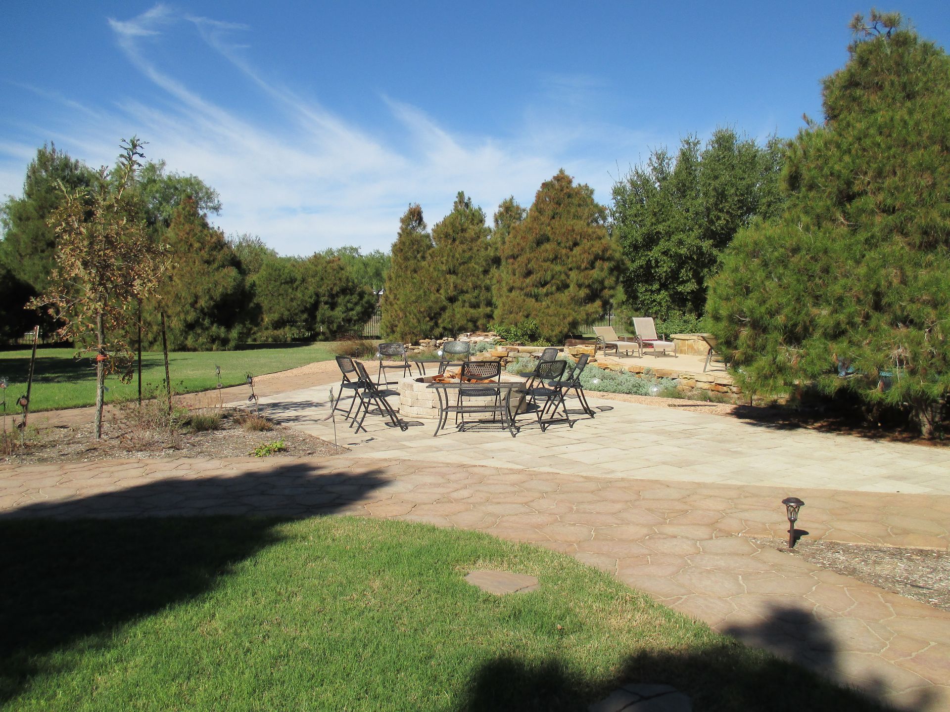 A shadow of a person is cast on the ground in a park