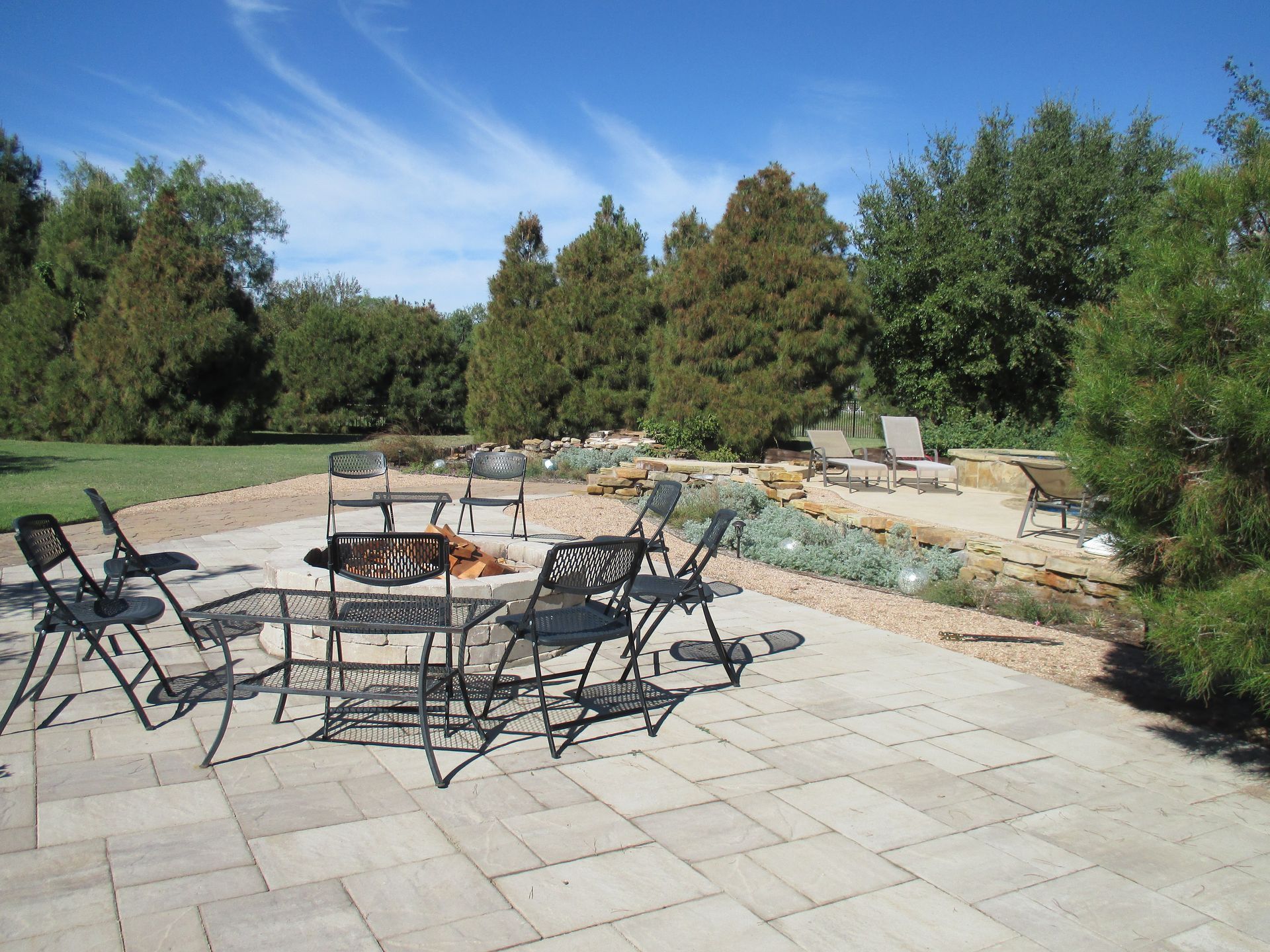 A patio with a table and chairs and a fire pit