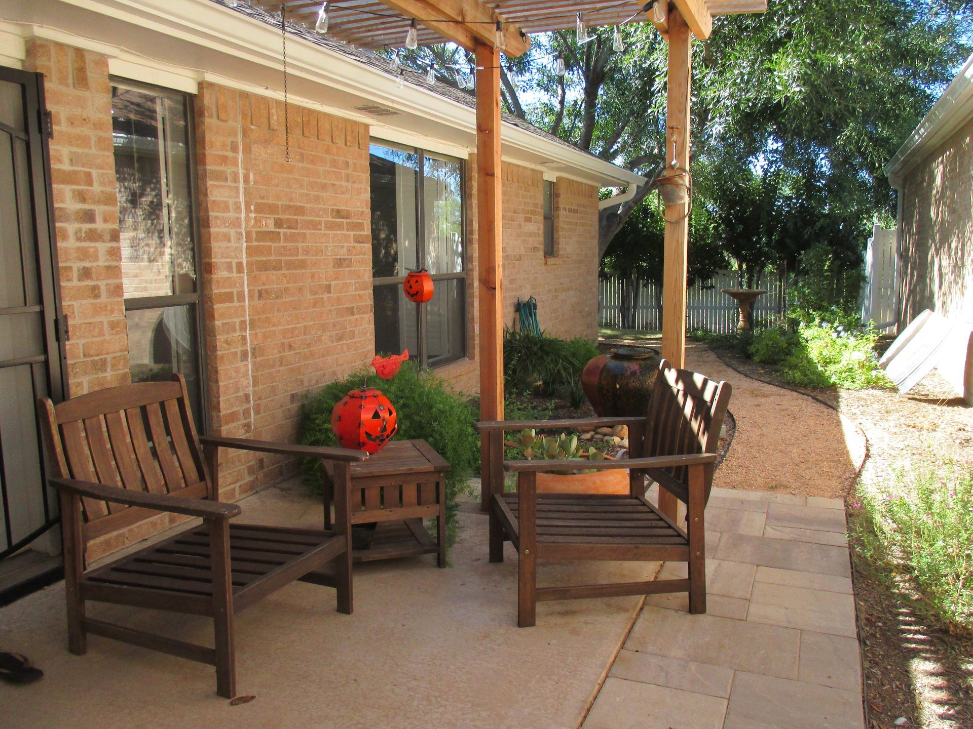 A patio with chairs and a table under a pergola