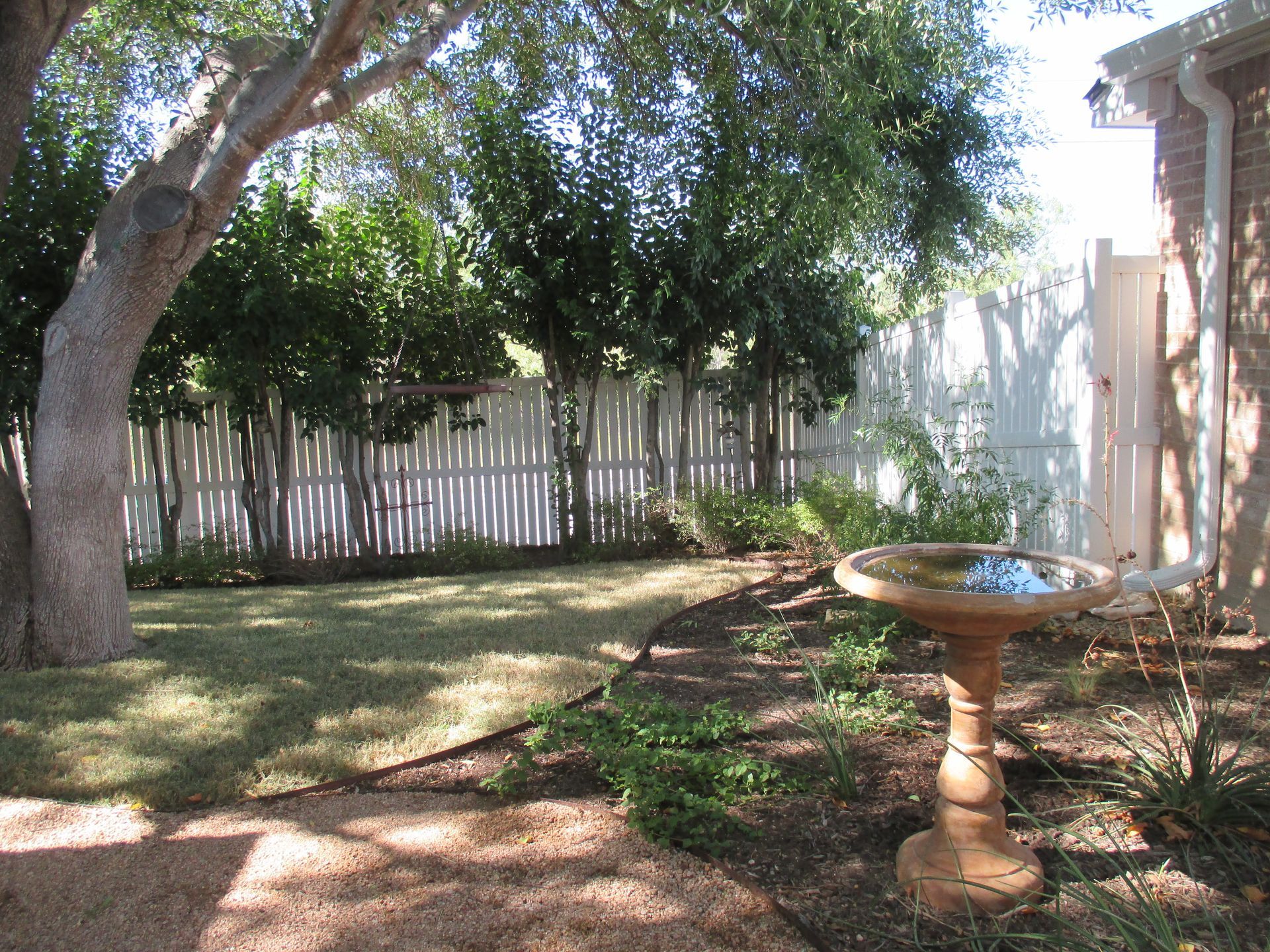 A bird bath in the backyard of a house