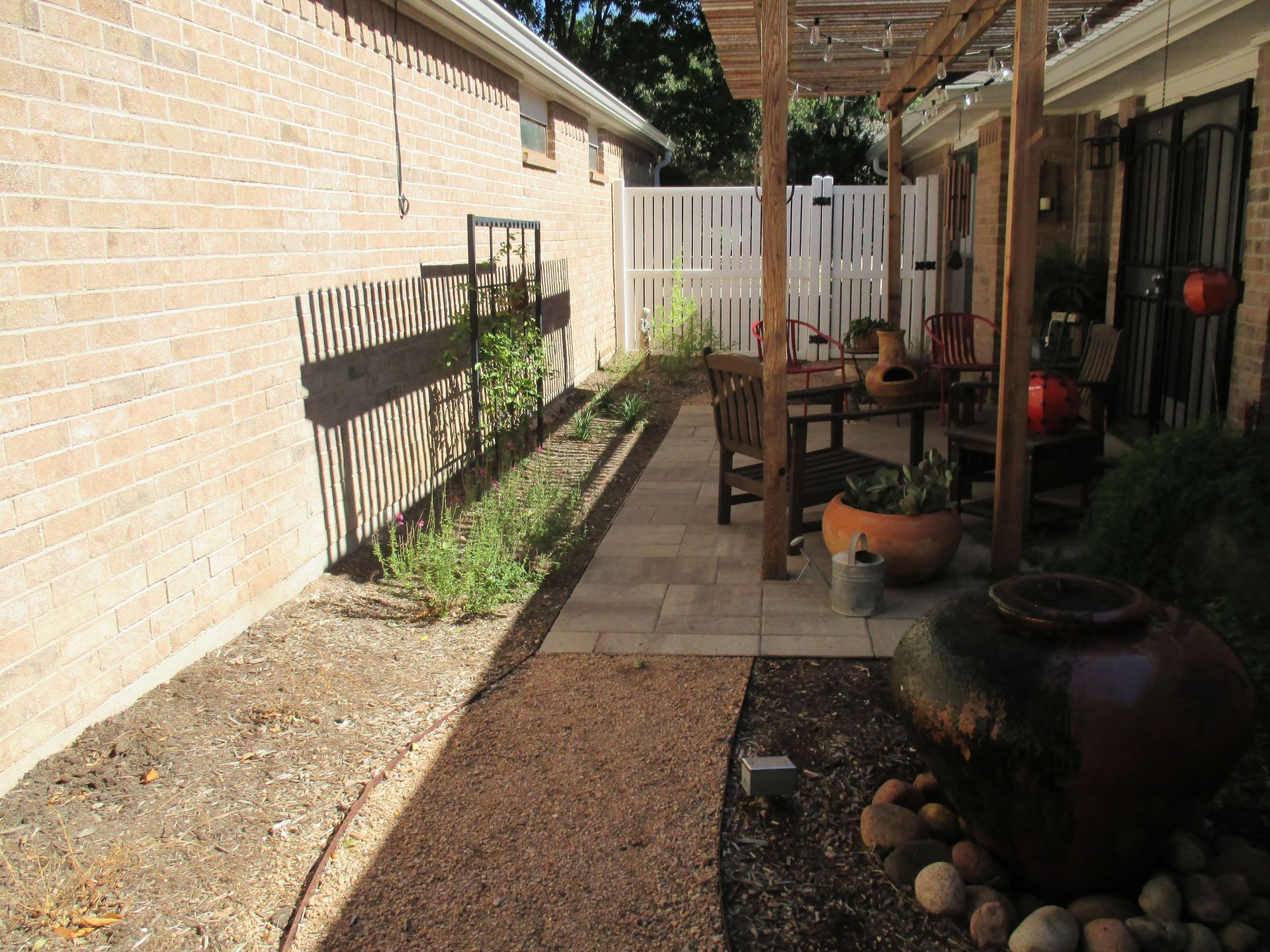 A brick house with a patio and a white fence