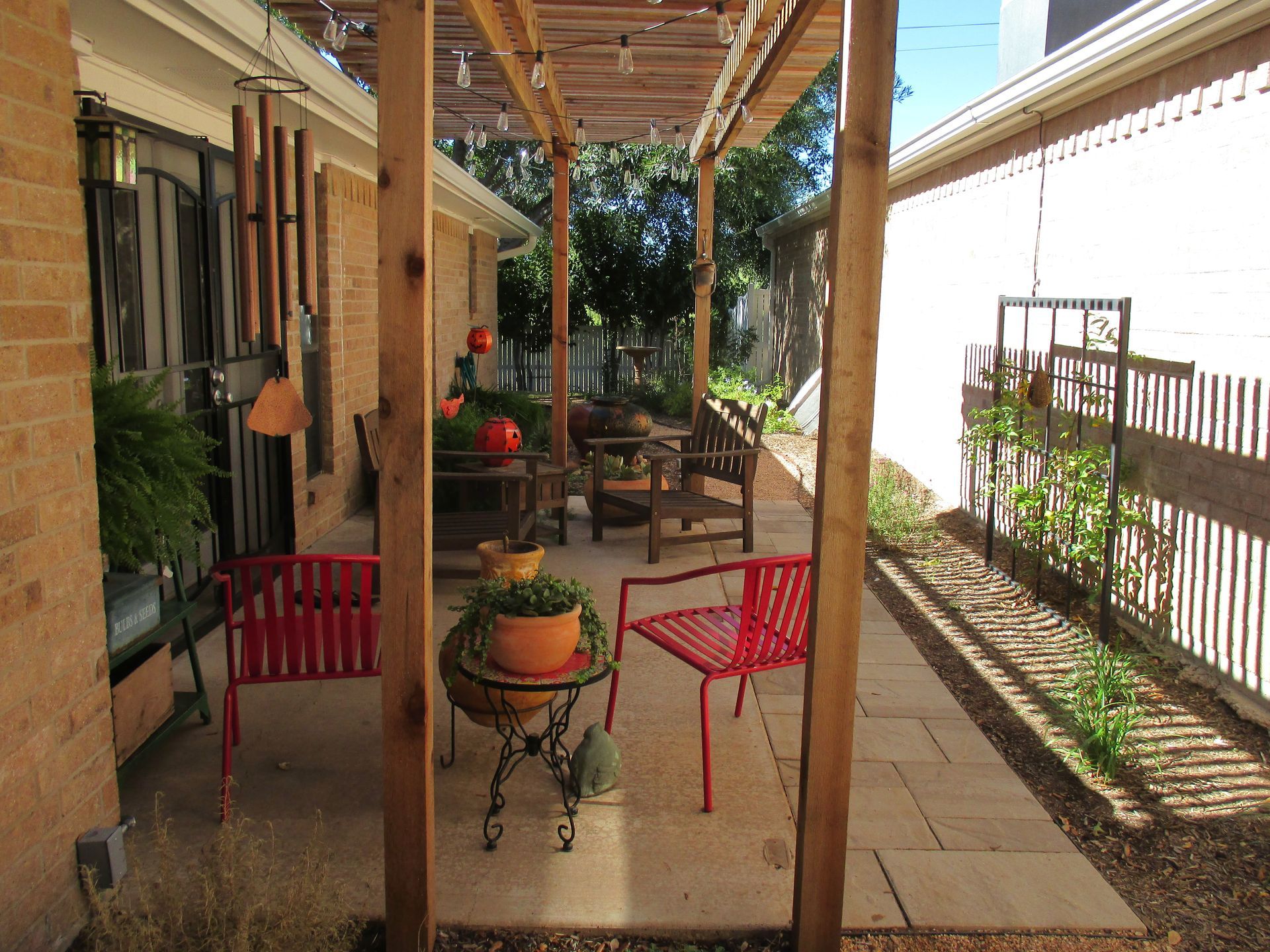 A patio with chairs and a table under a pergola