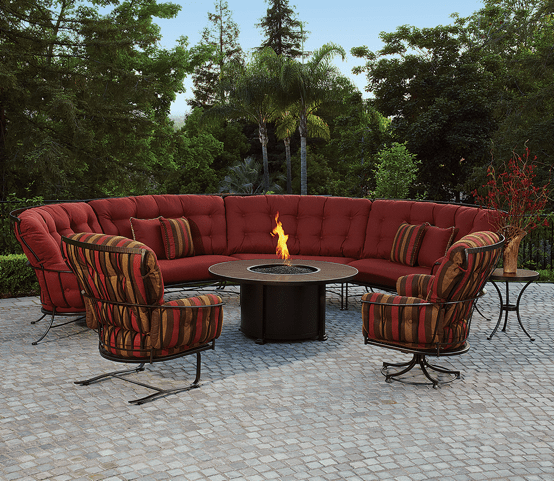 A patio with a couch and chairs and a fire pit