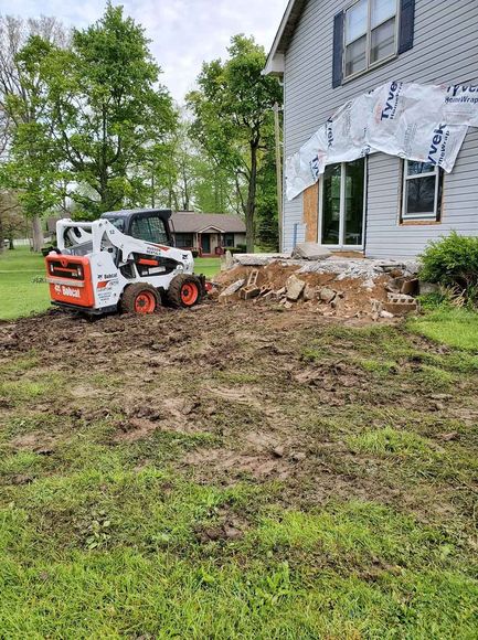 Skid steer loader in front of a house — New Castle, IN — Ram Outdoor Services LLC