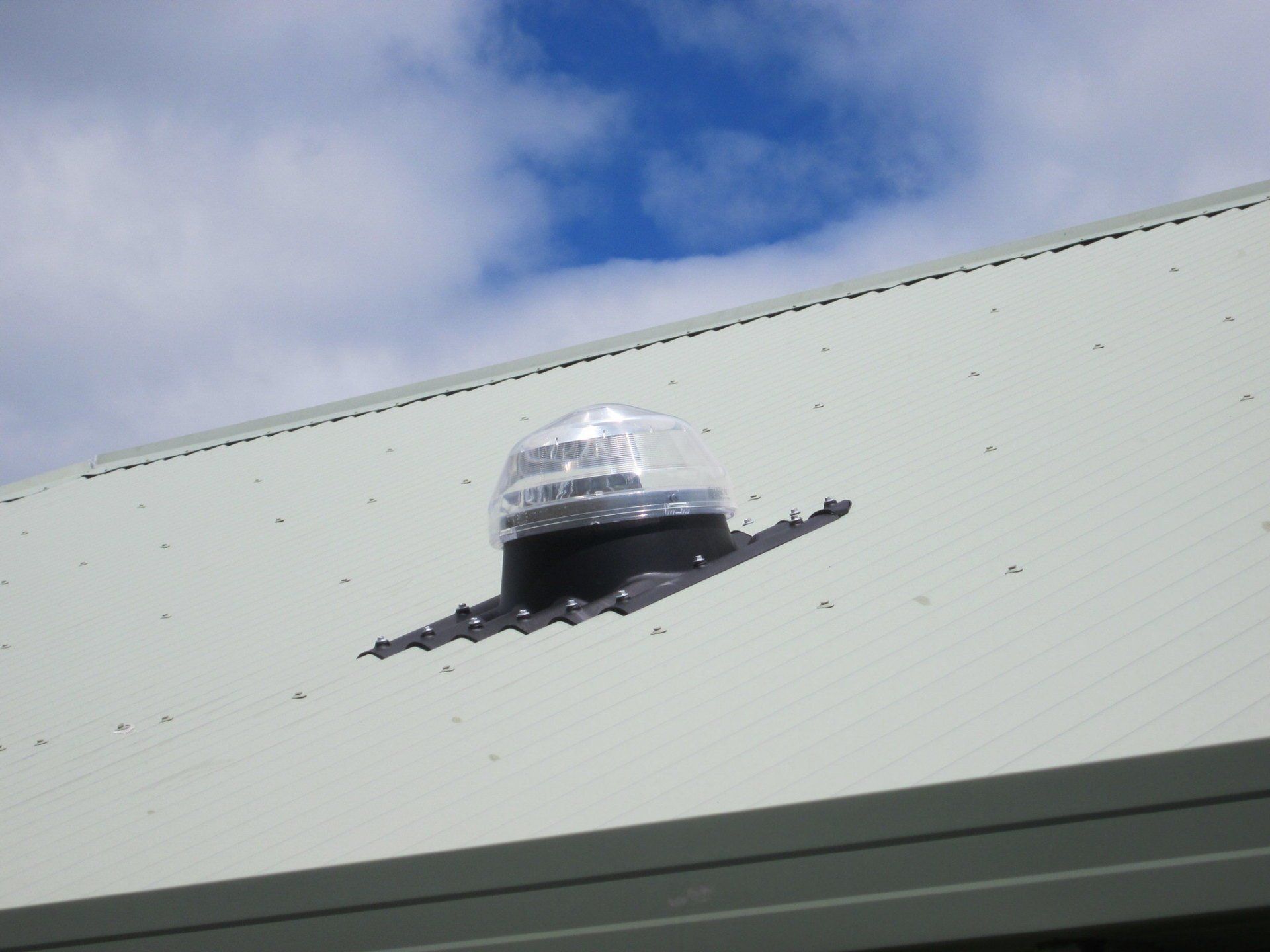 A light on the roof of a building with a blue sky in the background