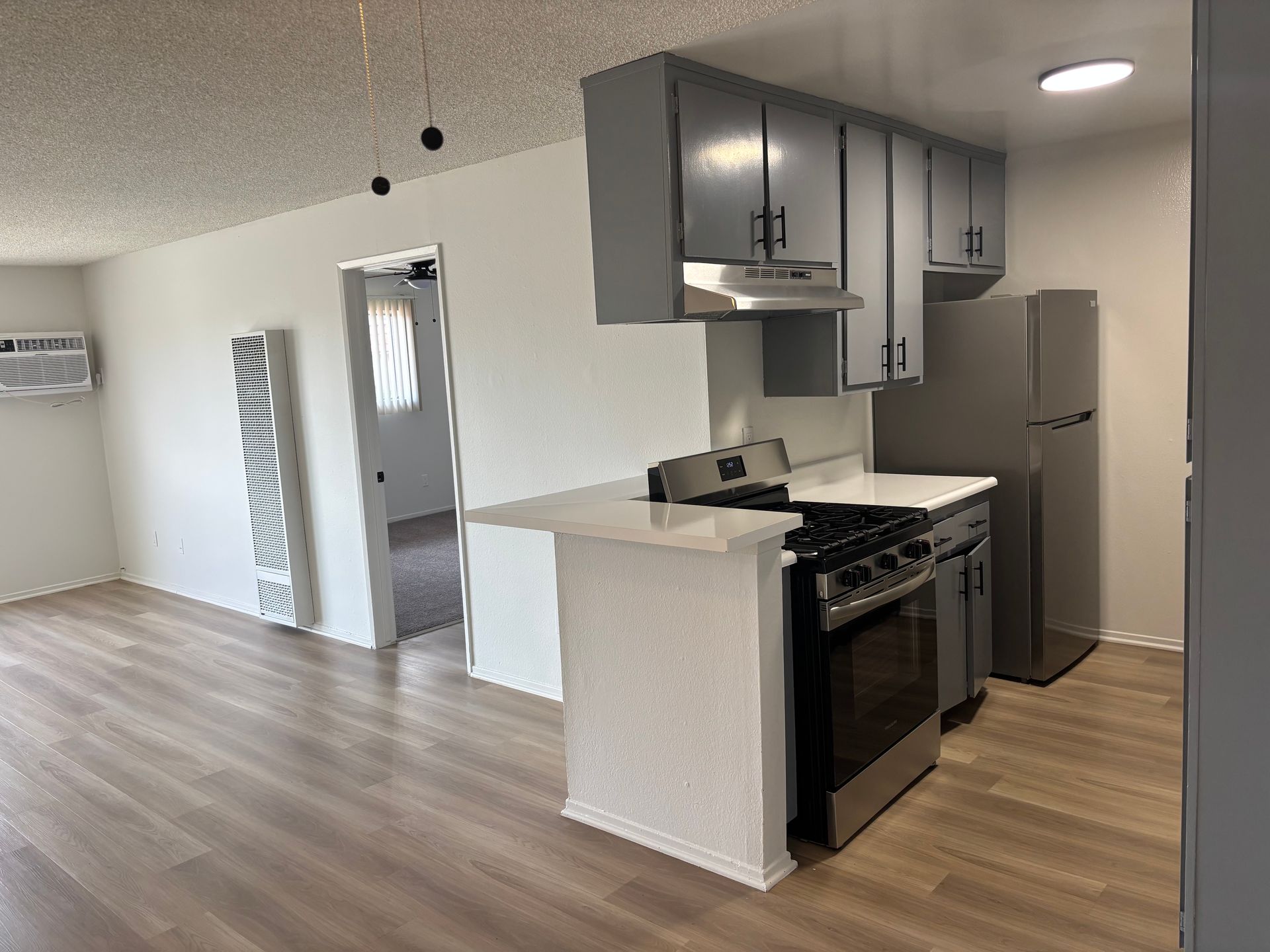 Photo of kitchen with stove, cabinets, and refrigerator