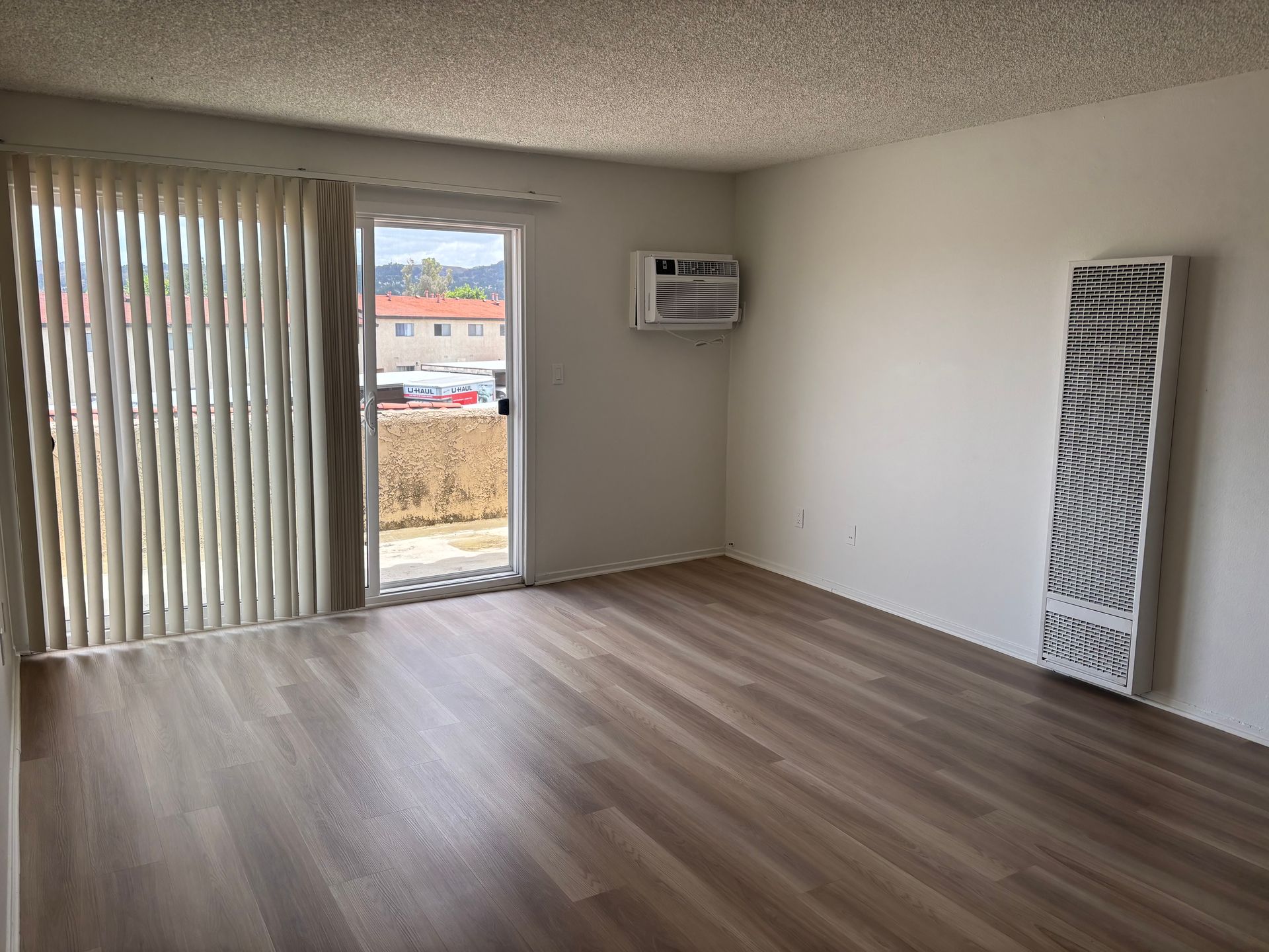 Photo of living room with wood flors and a sliding glass door