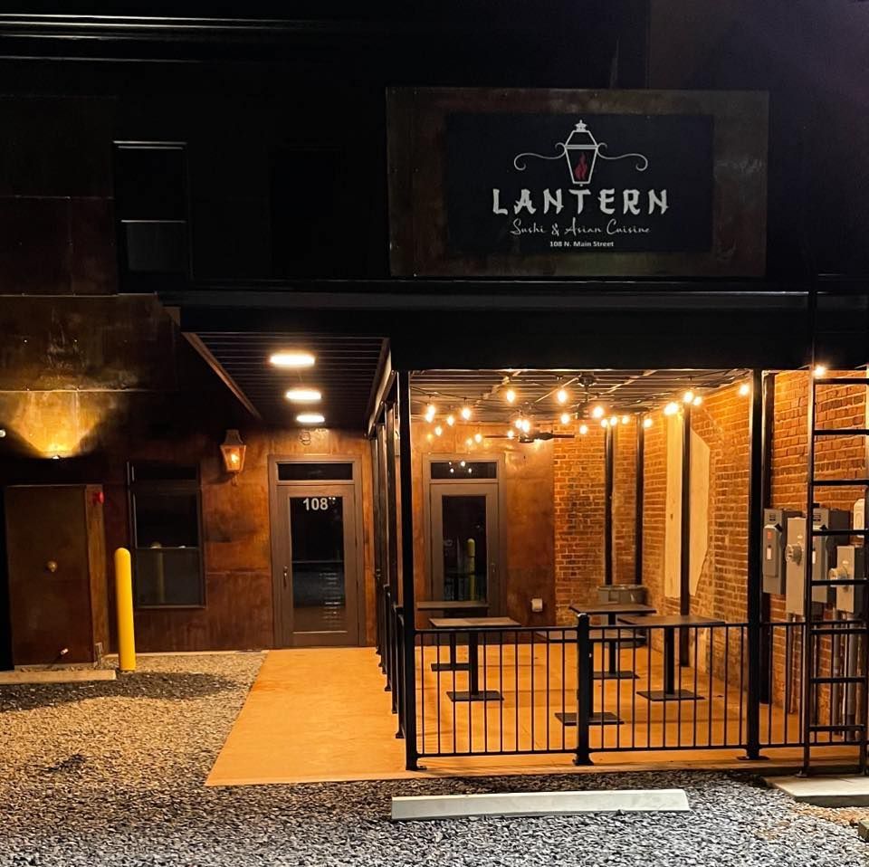 Exterior of Lantern Soda & Ice Cream shop at night, with string lights and brick facade.