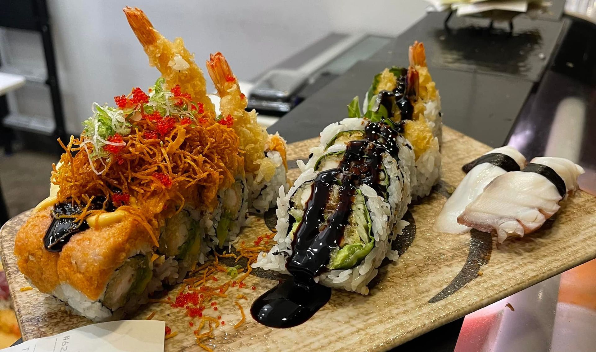 Sushi platter: dragon roll, avocado roll, octopus nigiri, and tempura shrimp.