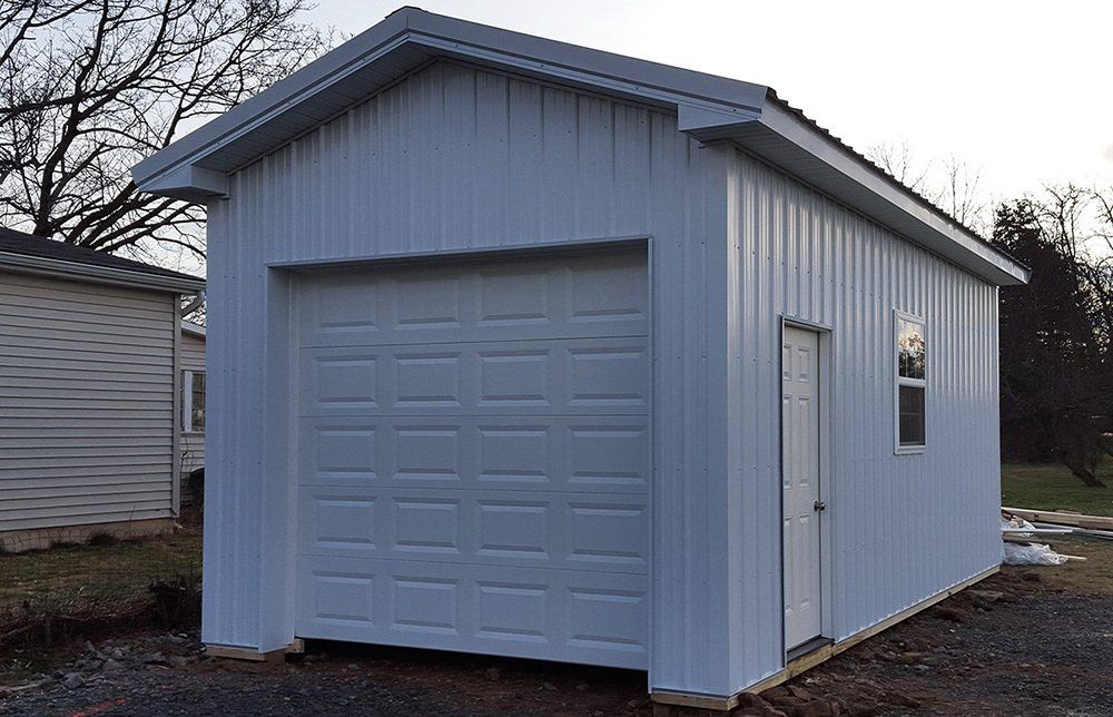 A white garage with a large garage door and a window.