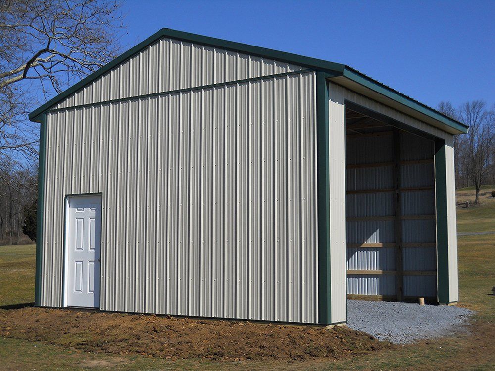 A metal building with a green roof and a white door