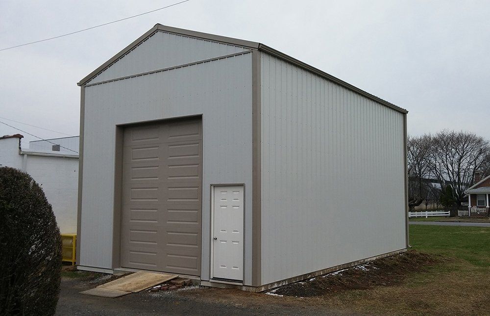A white garage with a brown door and a ramp.