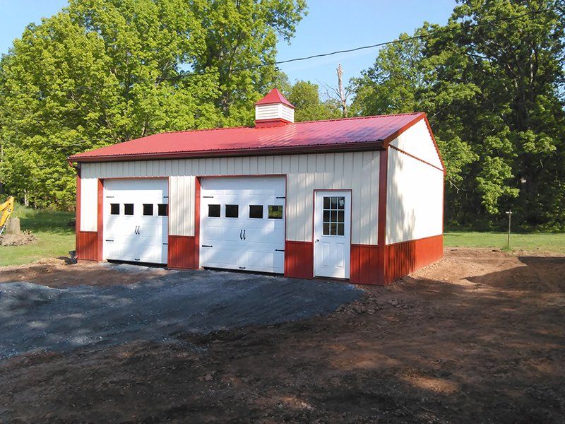 A white and red garage with a red roof