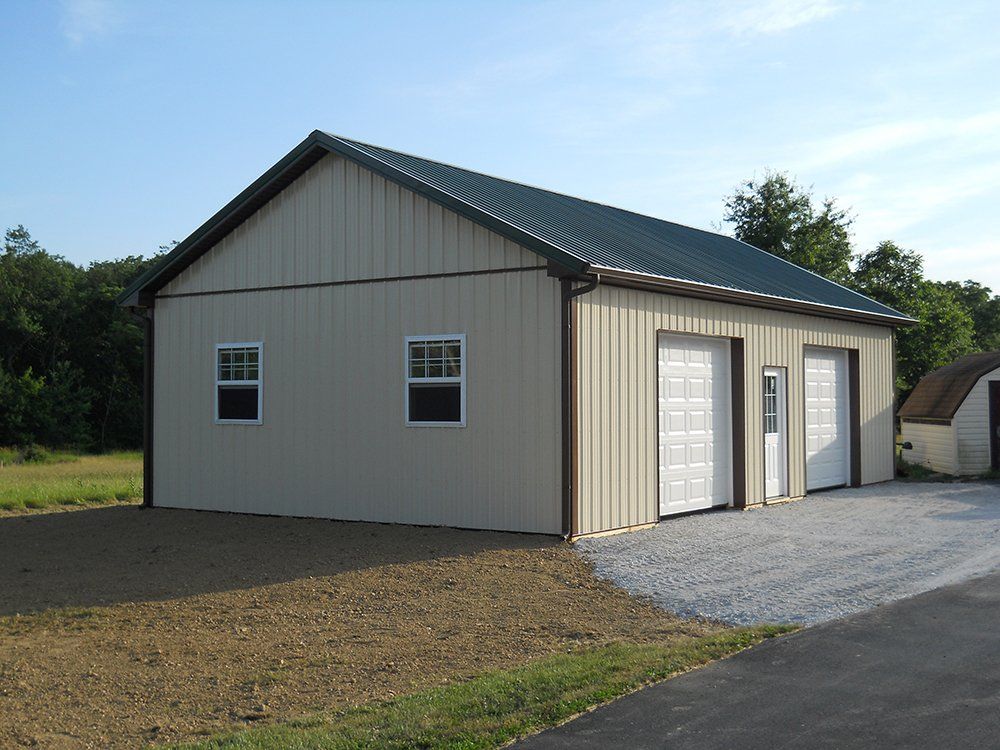 A garage with a green roof and white doors