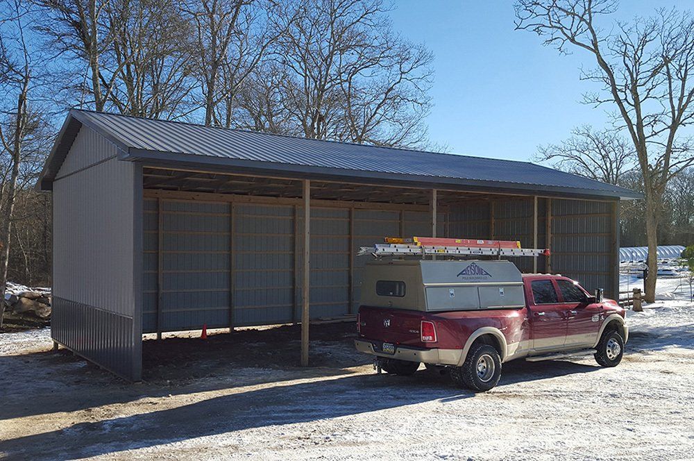A red truck is parked in front of a building in the snow.