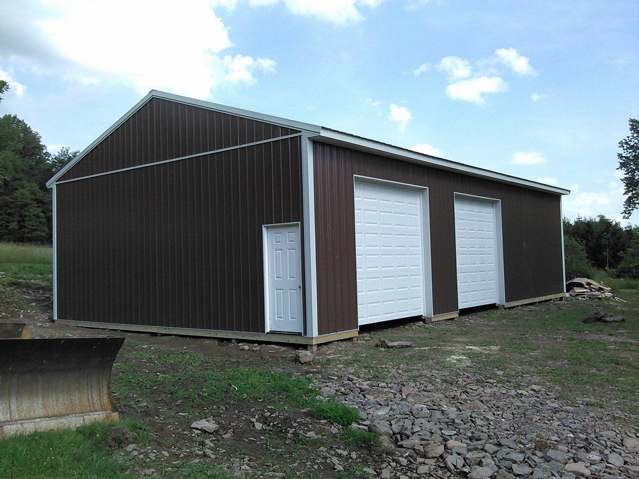 A brown building with white doors is sitting on top of a dirt hill.