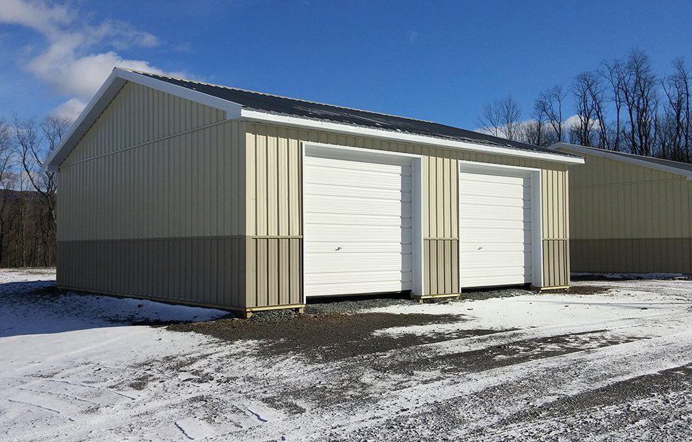 A garage with two white garage doors in the snow