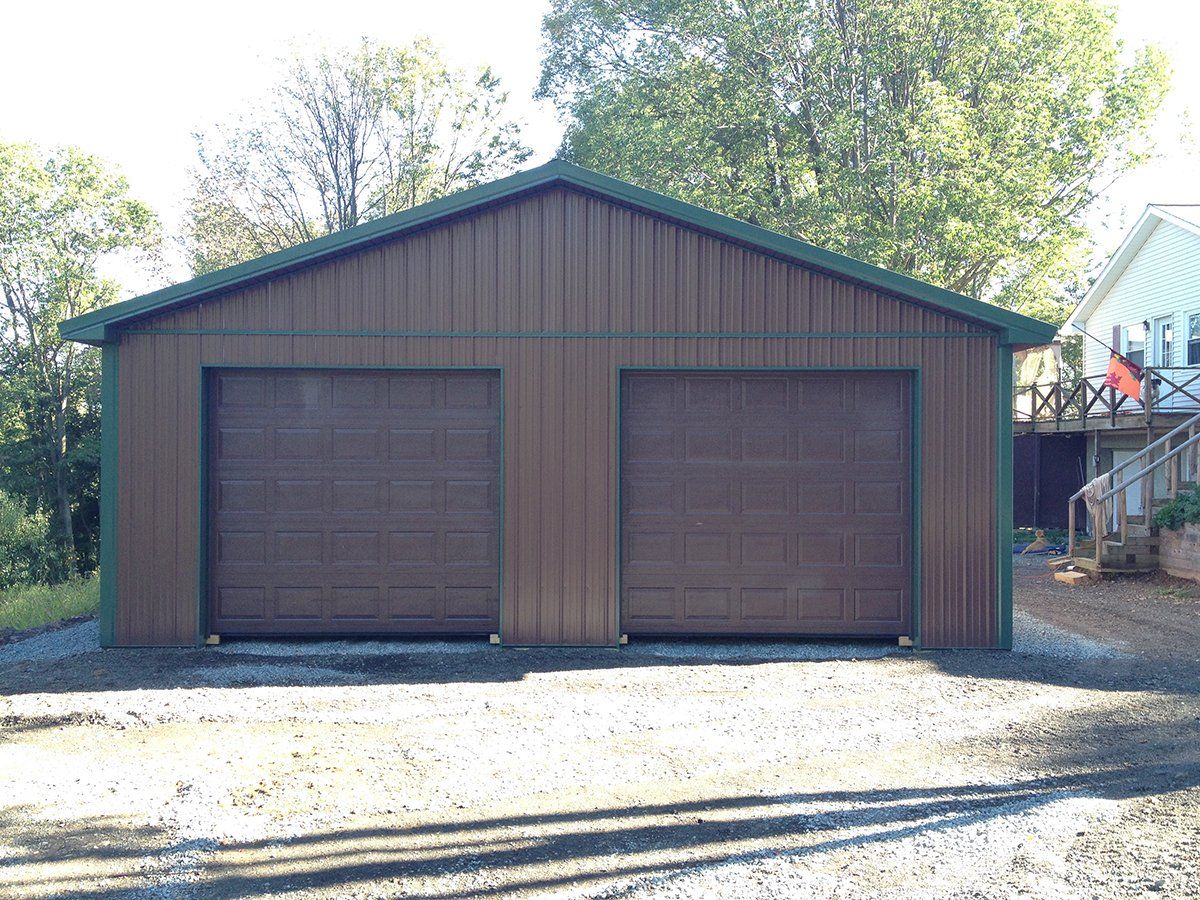 A garage with two garage doors and a green roof.