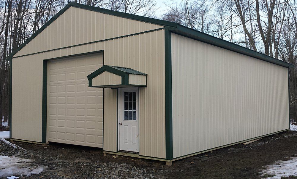 A large metal building with a green roof and a door.