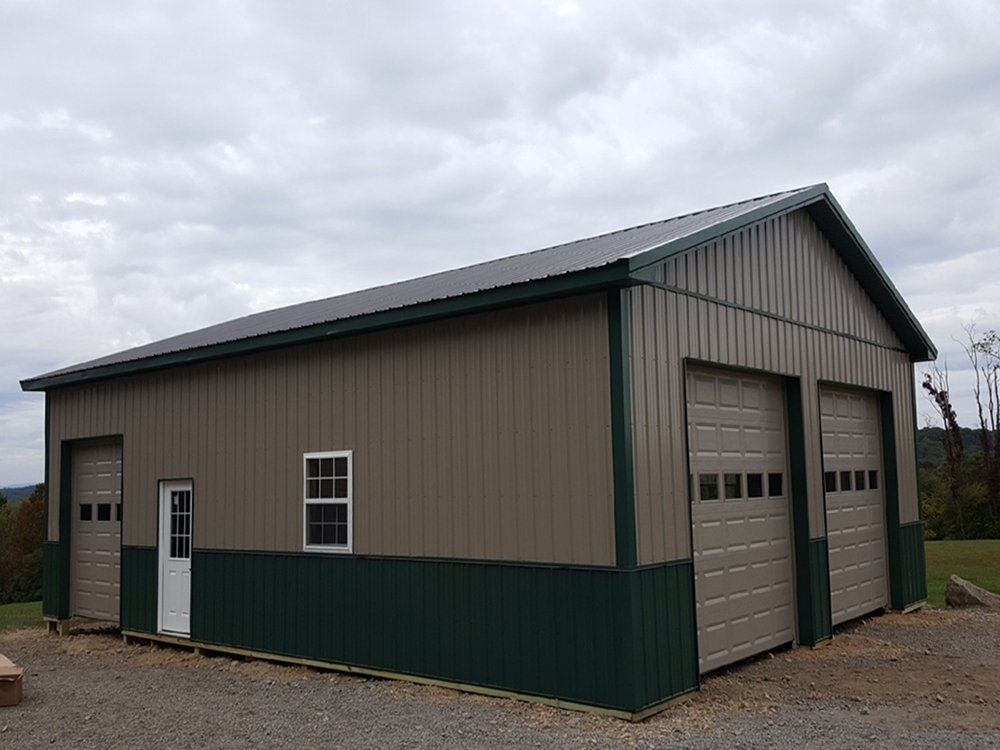 A large metal building with two garage doors and a window.
