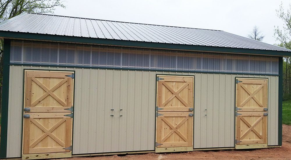 A barn with wooden doors and a metal roof
