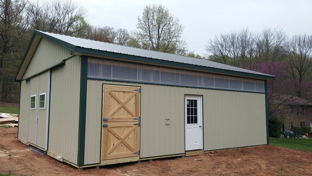 A large metal building with a green roof and a wooden door.