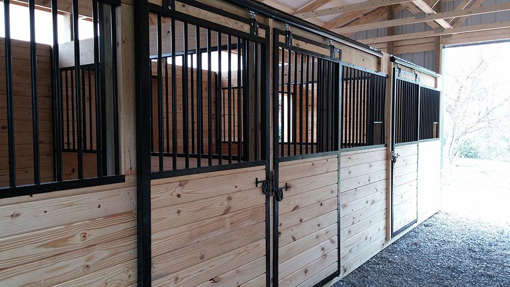 A horse stable with wooden walls and black metal bars.
