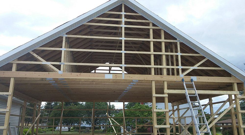A large wooden structure is being built with a ladder in front of it.