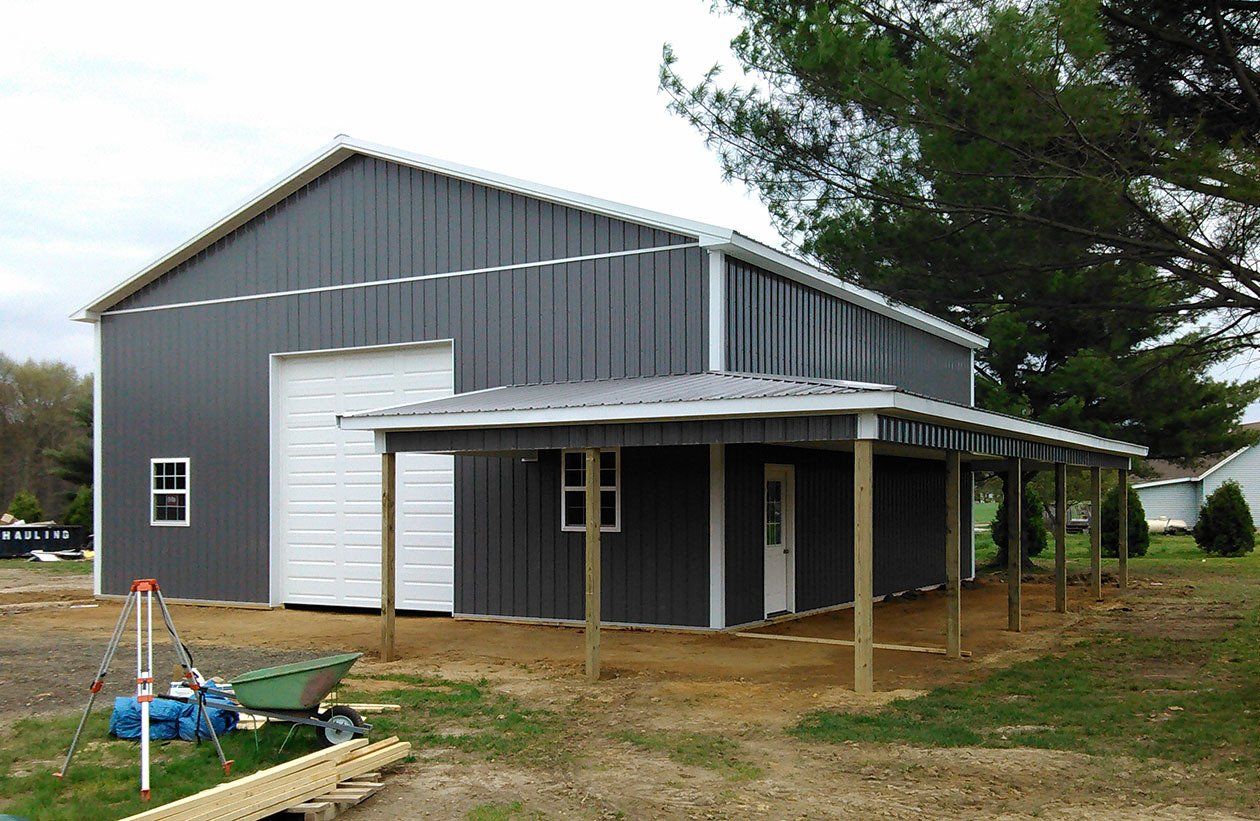 A large gray building with a white door and a porch