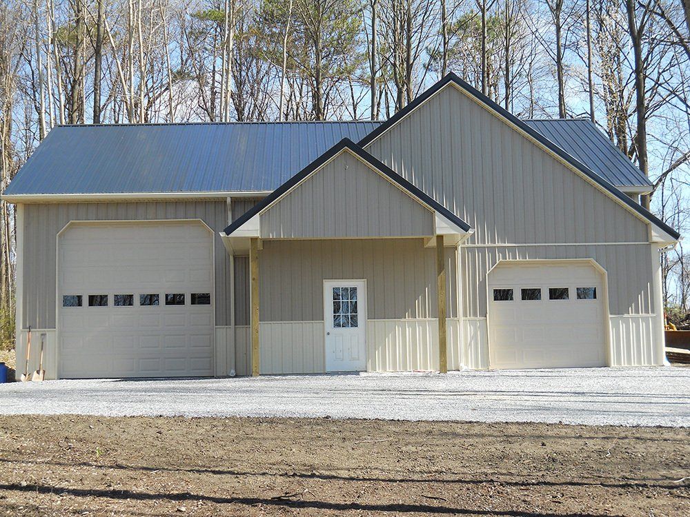 A house with two garage doors and a black roof
