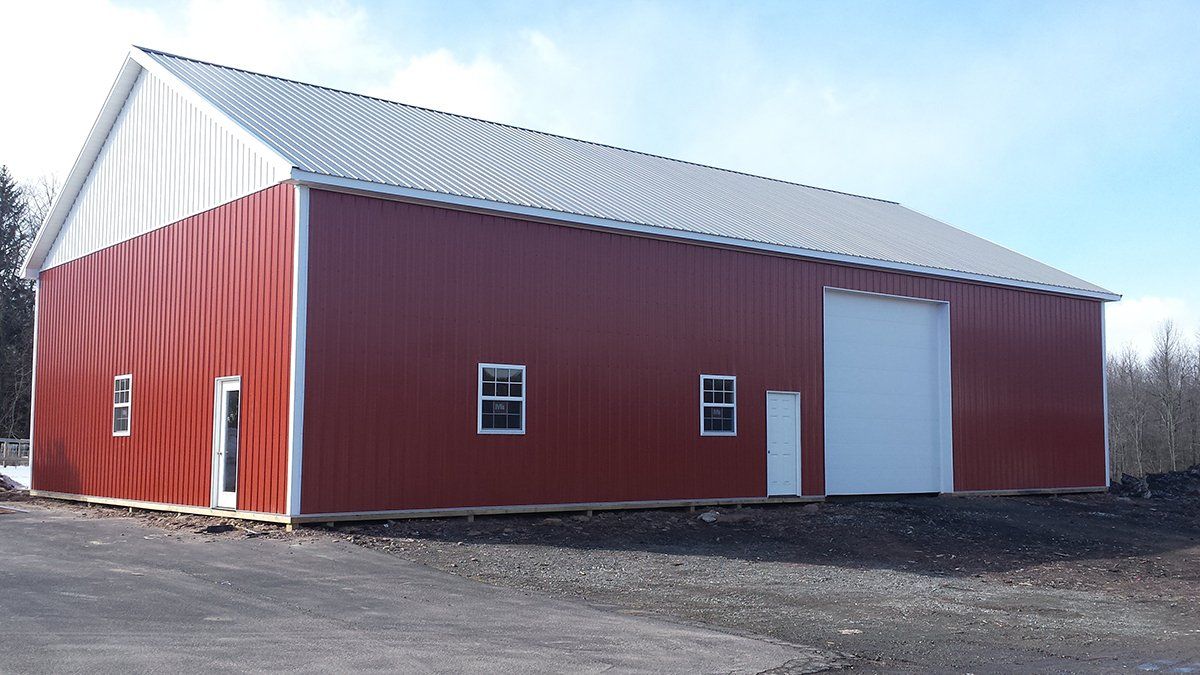 A large red barn with a white roof and windows