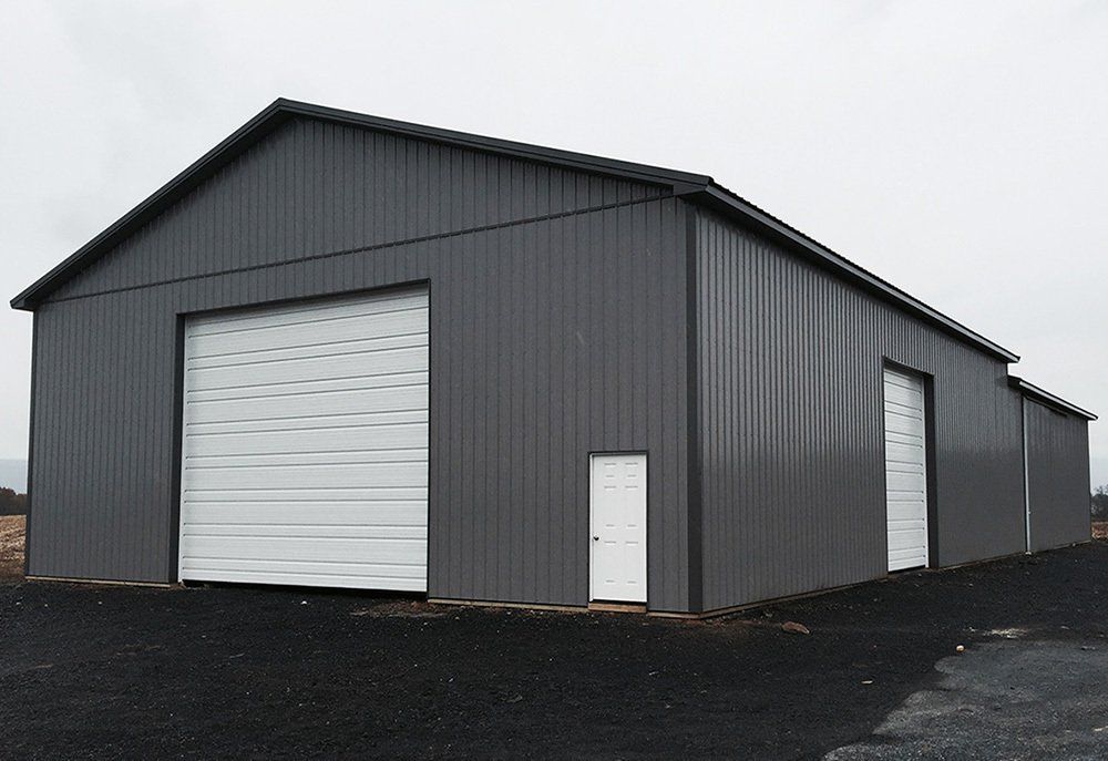 A large gray building with a white garage door