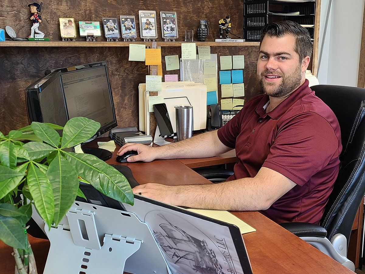 A man is sitting at a desk in front of a computer.