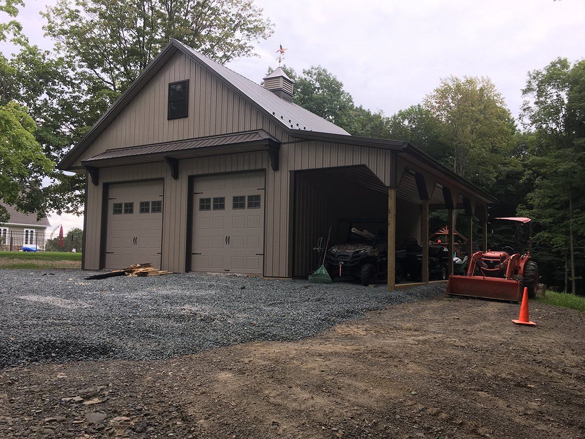 A garage with a tractor parked in front of it.