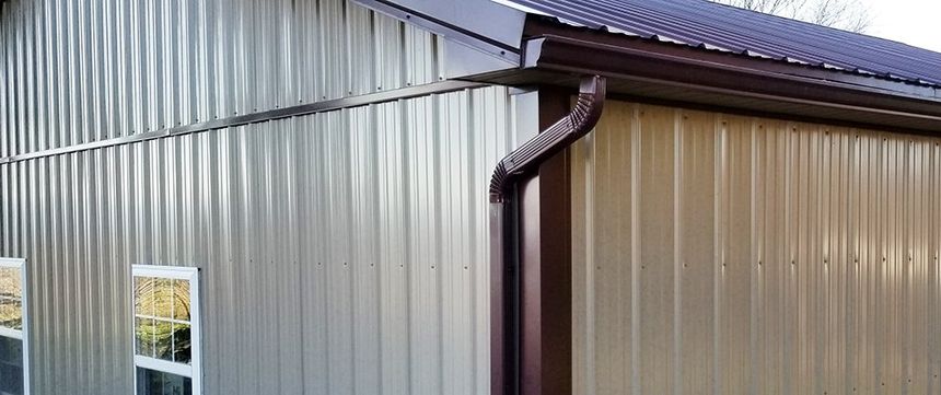 A metal building with a brown gutter on the side of it.