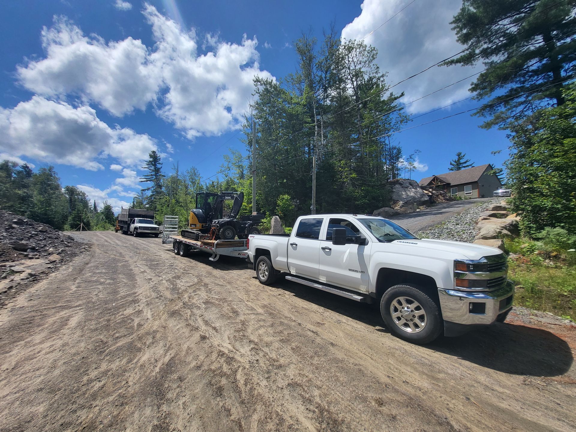 Un camion blanc est garé sur le bord d'un chemin de terre.