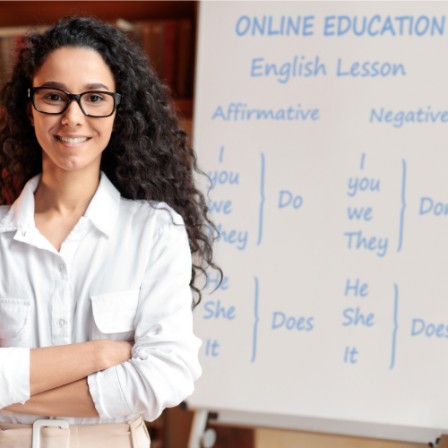 Woman standing in front of a whiteboard with her arms crossed.