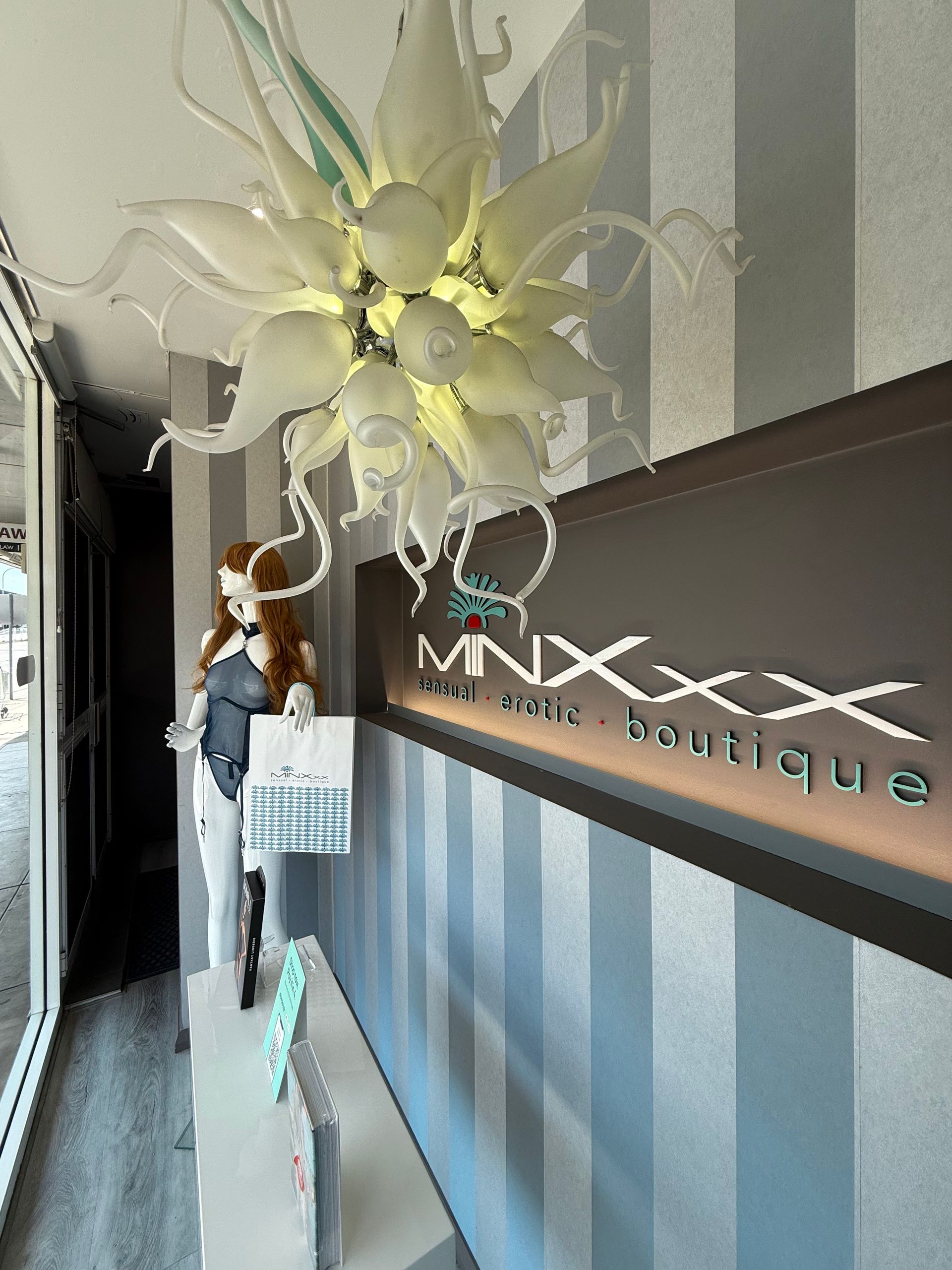 Boutique interior with a mannequin, sign reading 