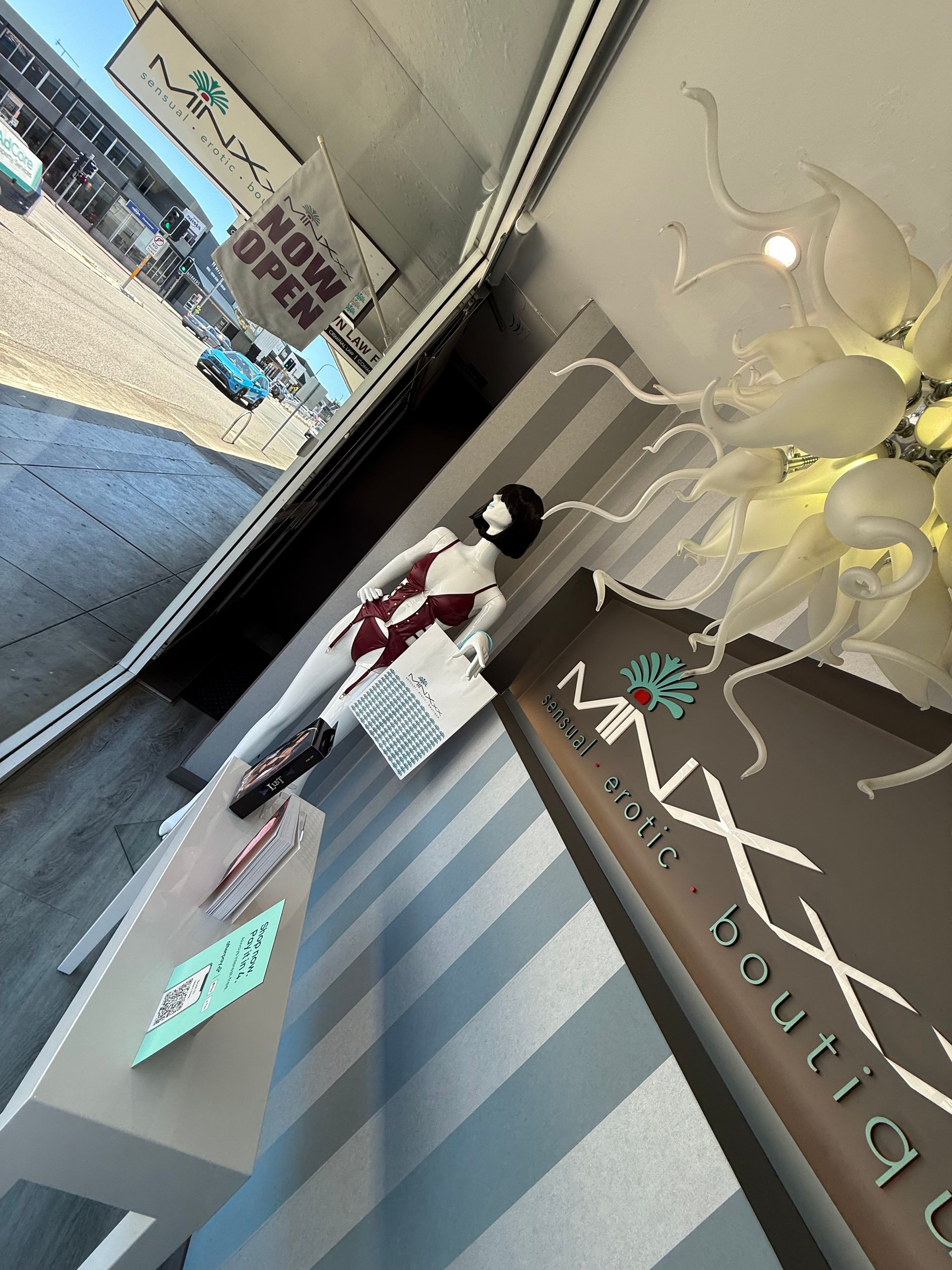 Boutique storefront with mannequin wearing a red outfit, 